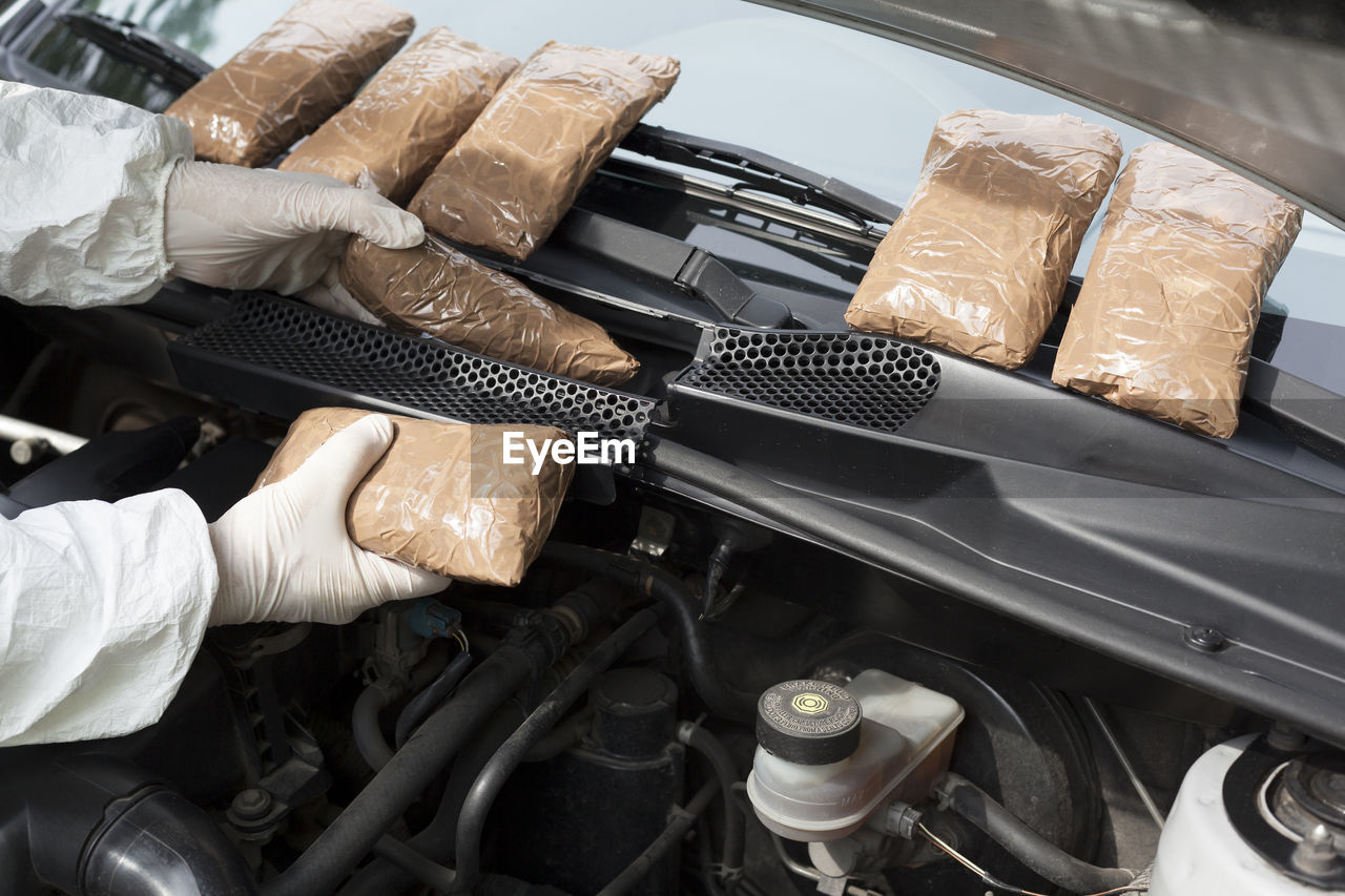 Cropped hands of person repairing car engine