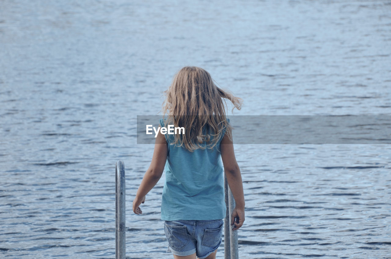 Rear view of girl standing in sea