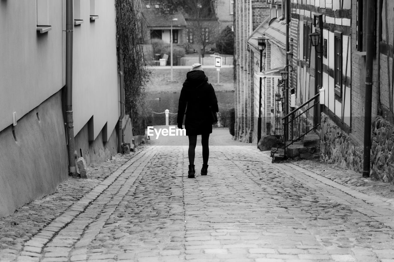 Rear view of woman walking on footpath