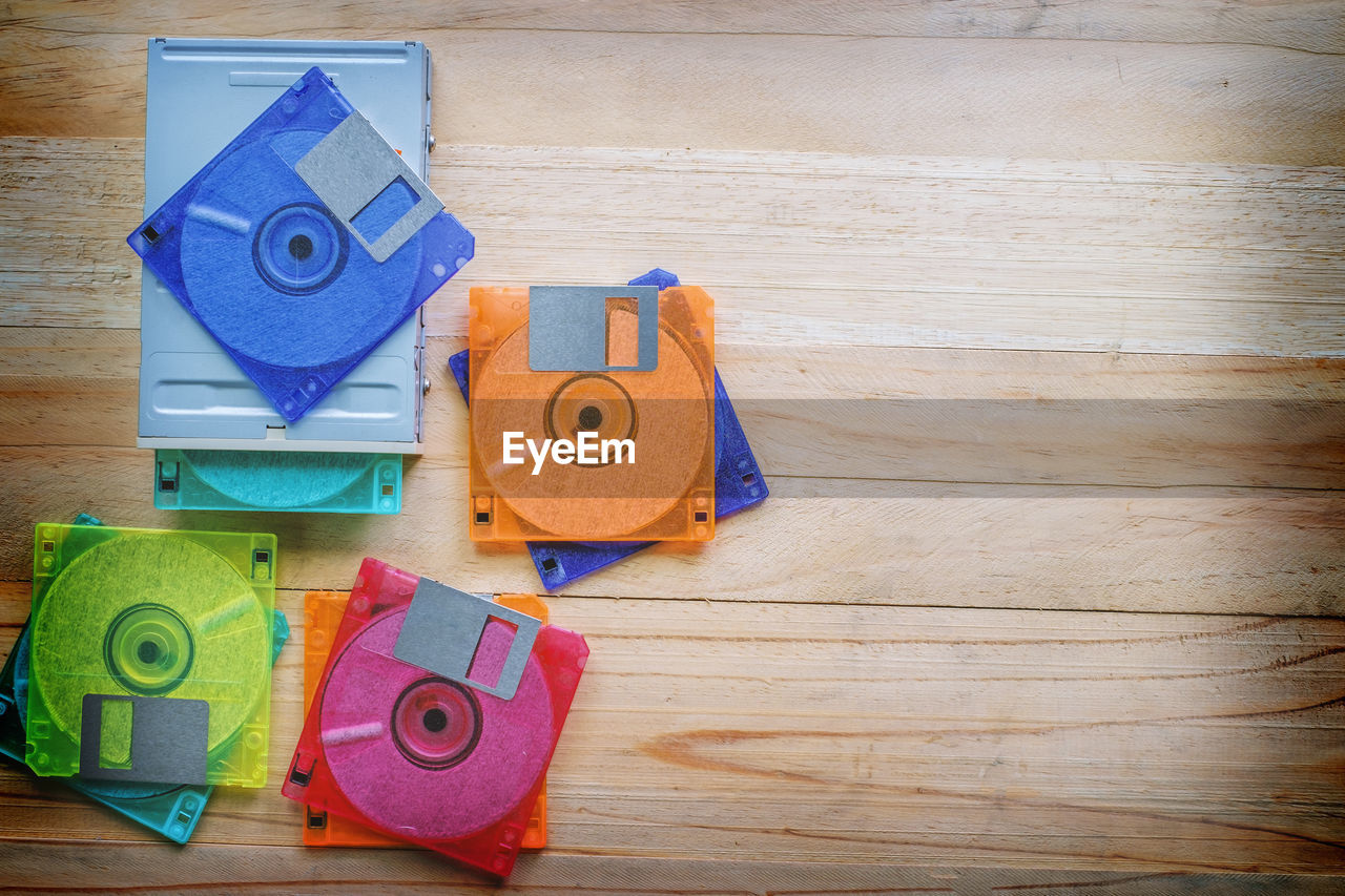 High angle view of colorful floppy discs on wooden table