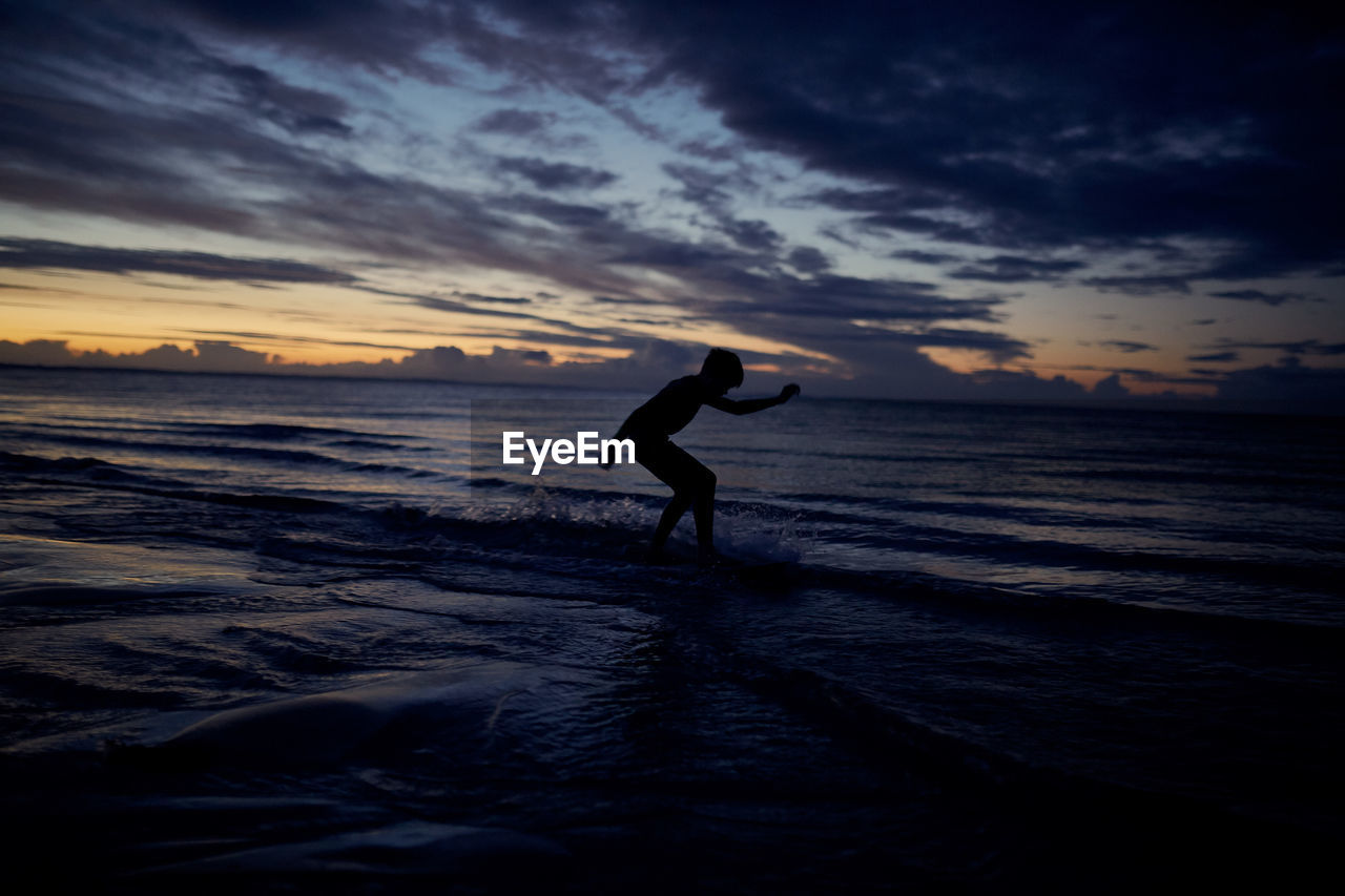 SILHOUETTE MAN ON BEACH DURING SUNSET