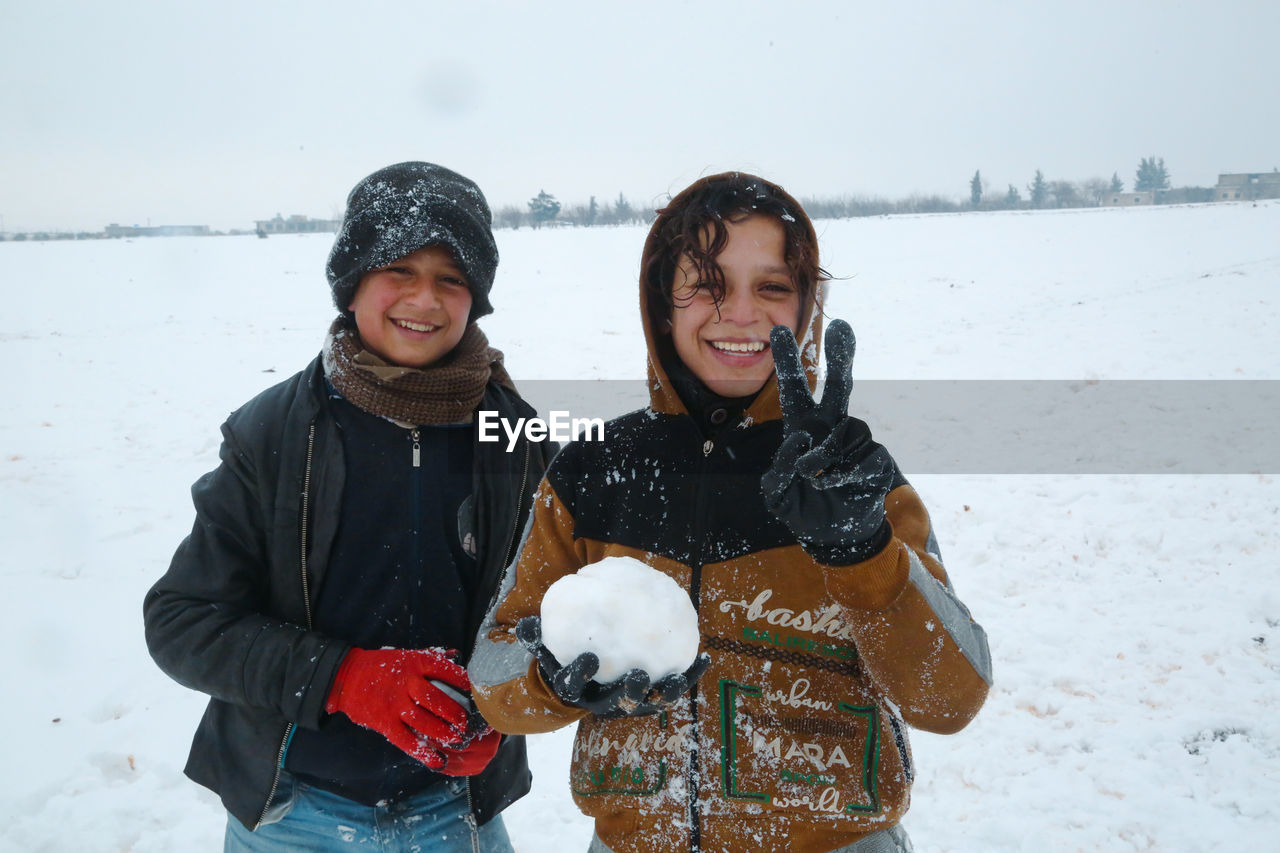 A syrian refugee child at the door of his snow covered tent