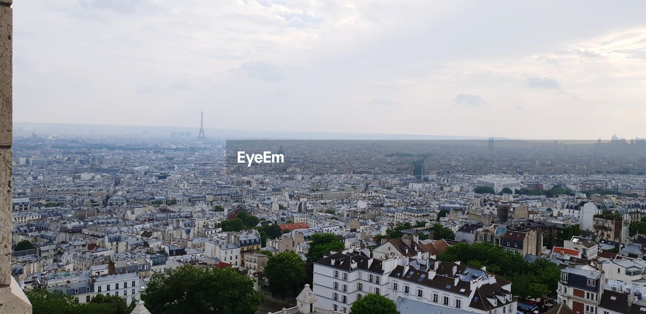 HIGH ANGLE VIEW OF CITYSCAPE AGAINST SKY