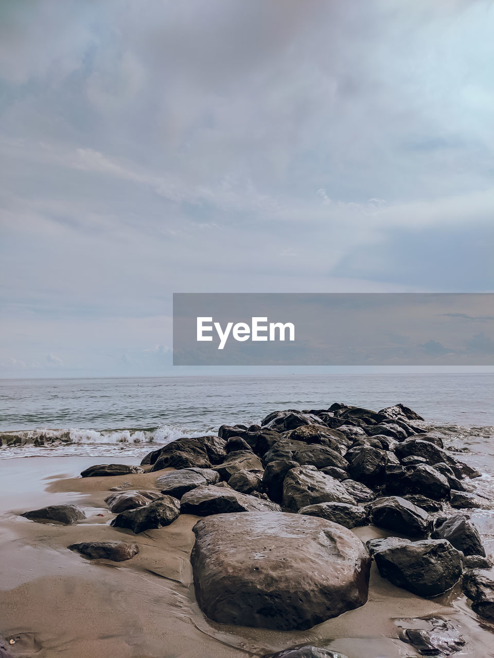 ROCKS ON SHORE AGAINST SKY