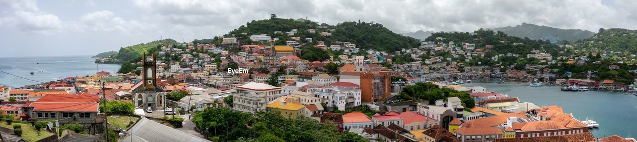 High angle view of townscape by sea against sky