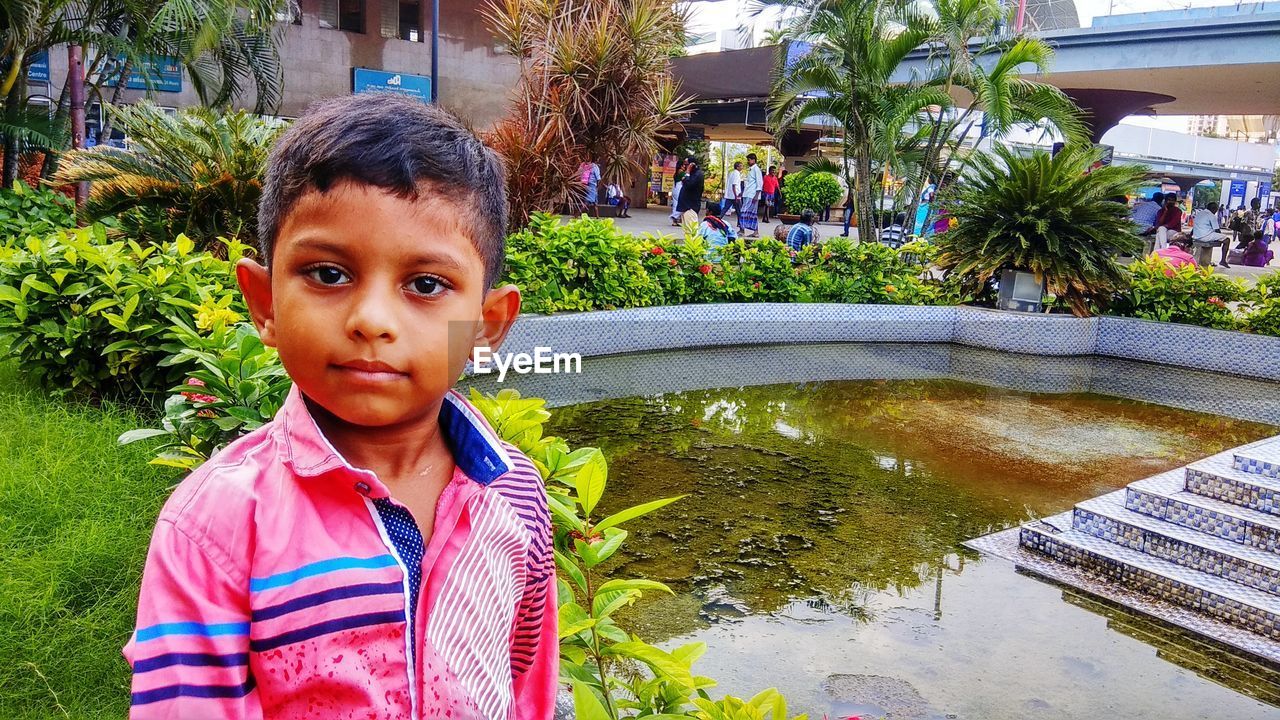 Portrait of cute boy standing in swimming pool