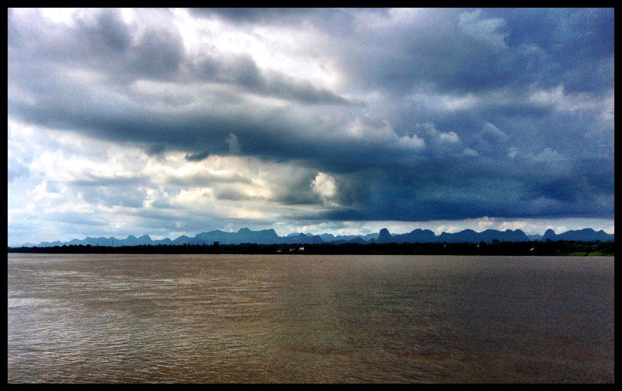 SCENIC VIEW OF SEA AGAINST CLOUDY SKY AT DUSK