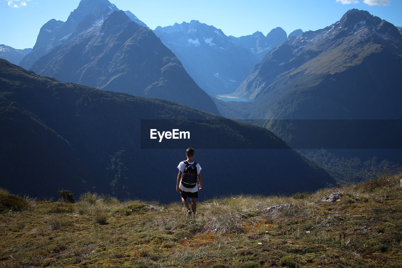 Rear view of man on mountain against sky