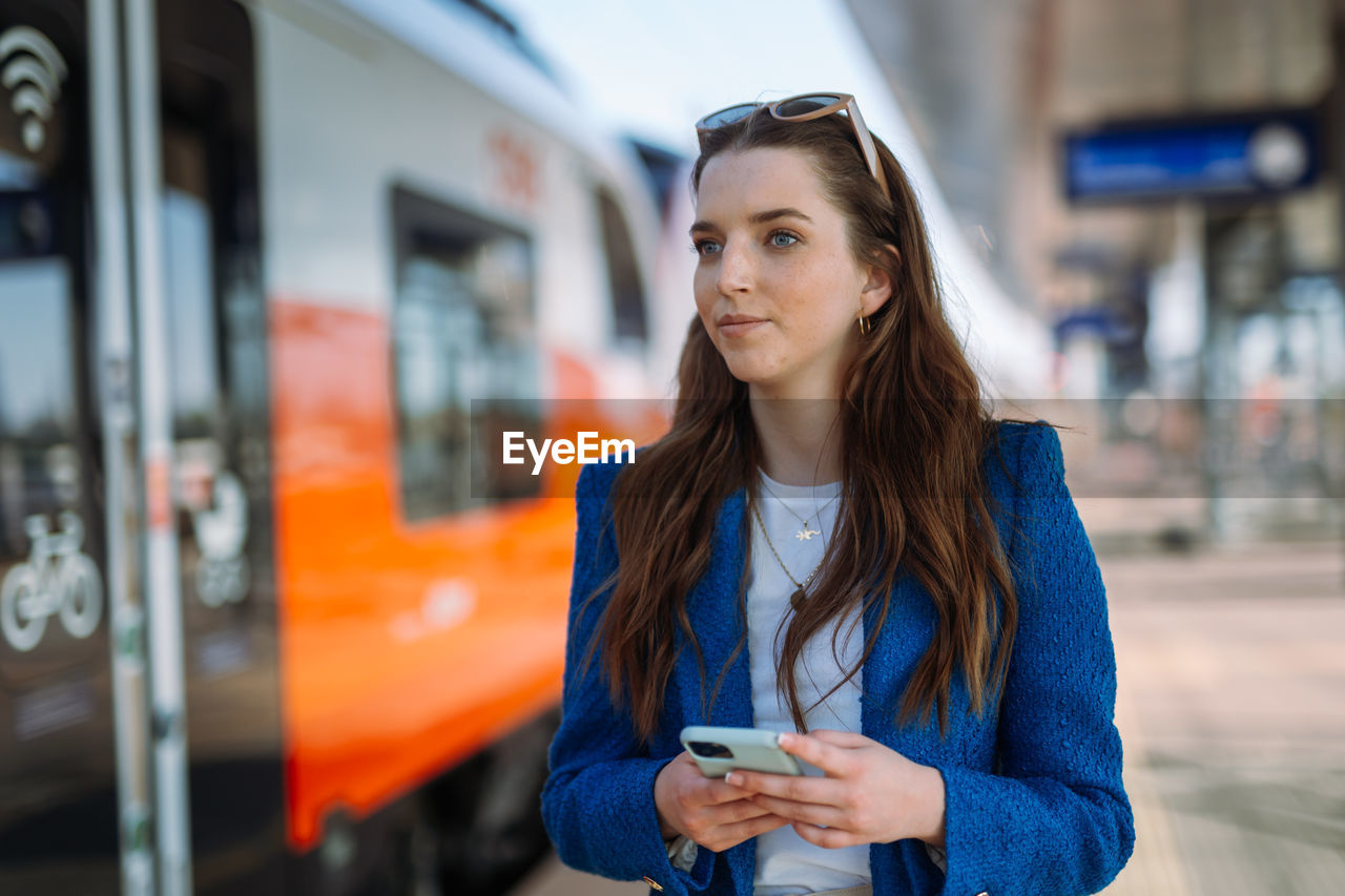 Woman entrepreneur commuting to work. using and holding mobile phone. public transport concept.