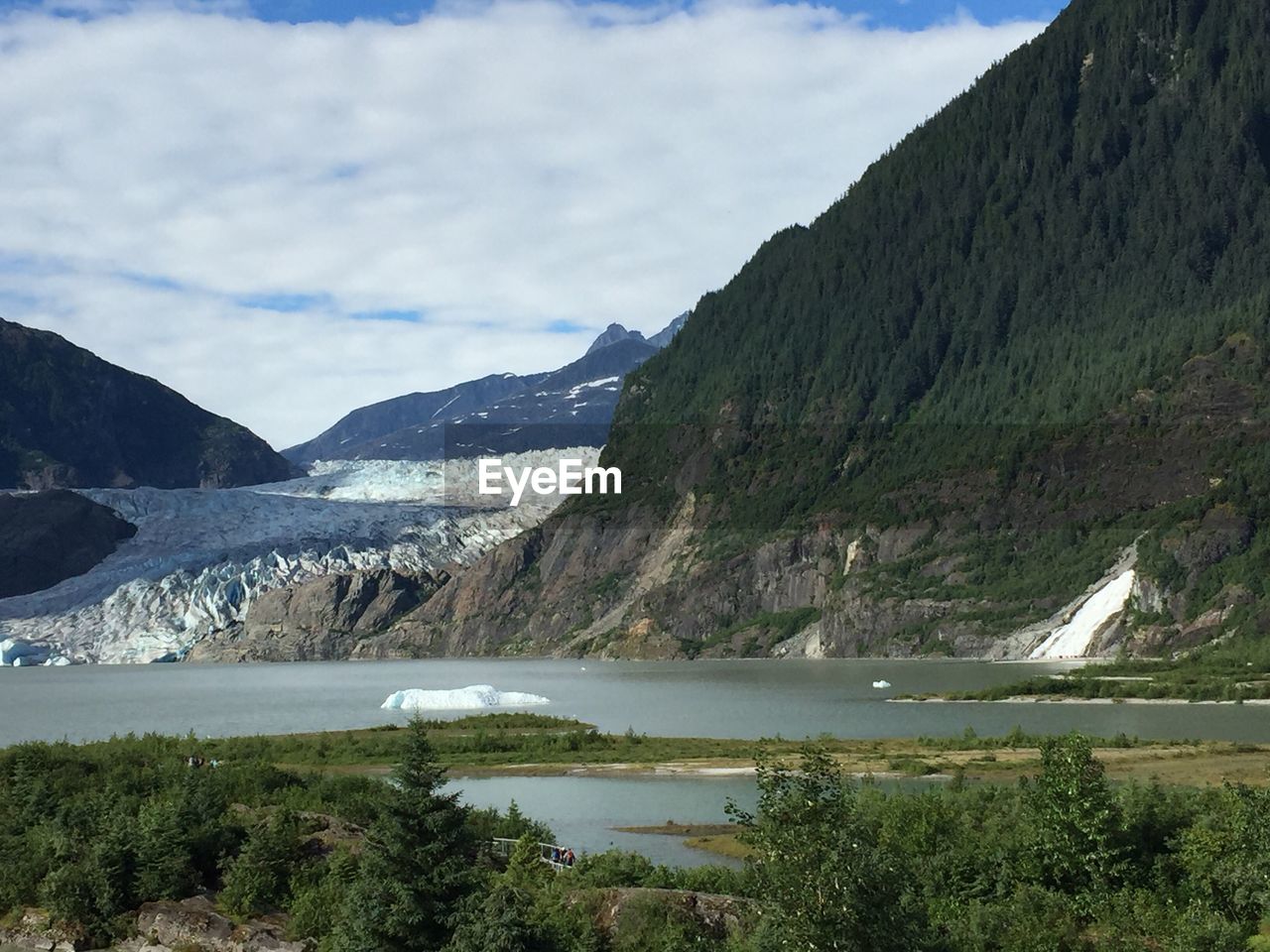 Scenic view of river and mountains against sky