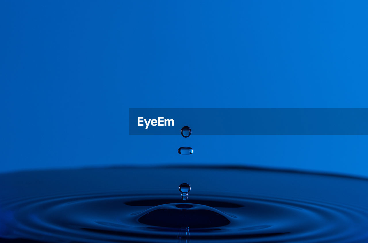 Close-up of drop on blue water