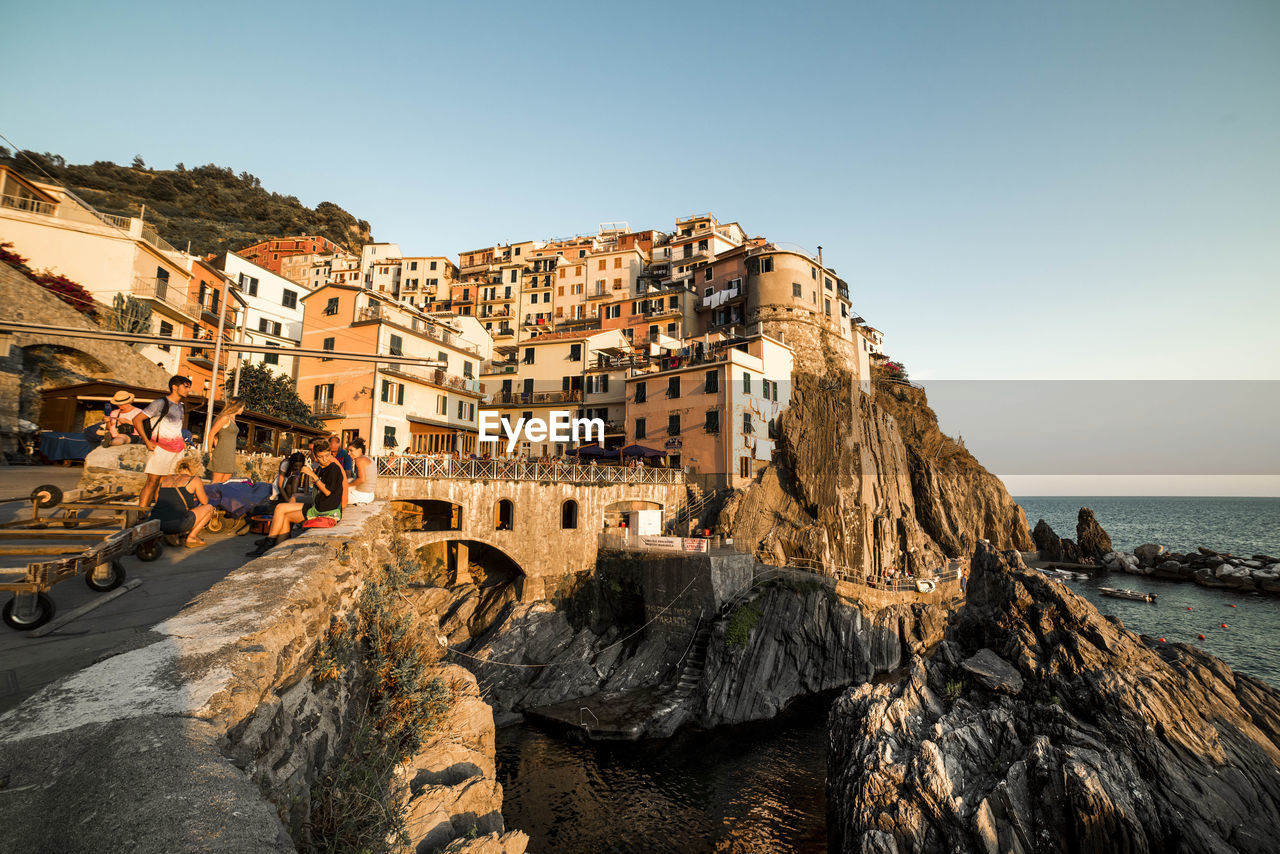 Houses on rock formation at manarola against clear sky