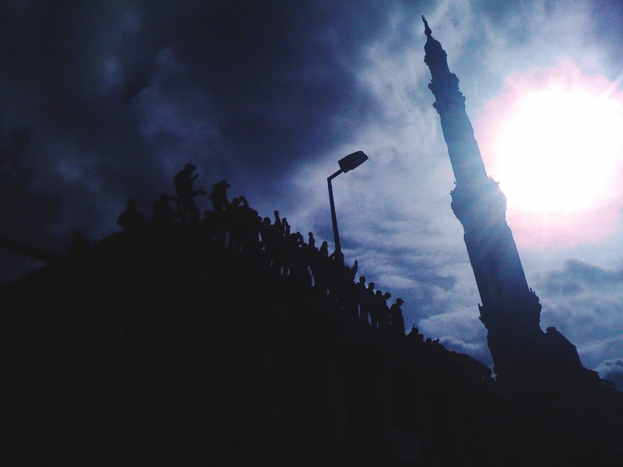 LOW ANGLE VIEW OF SUN SHINING THROUGH CLOUDS