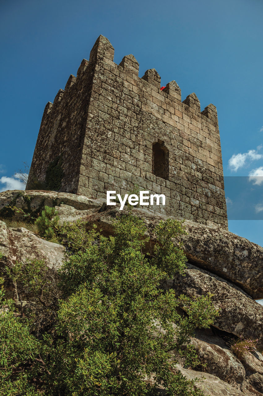 Square tower from keep made of stone over rocky terrain at the sortelha castle. portugal.