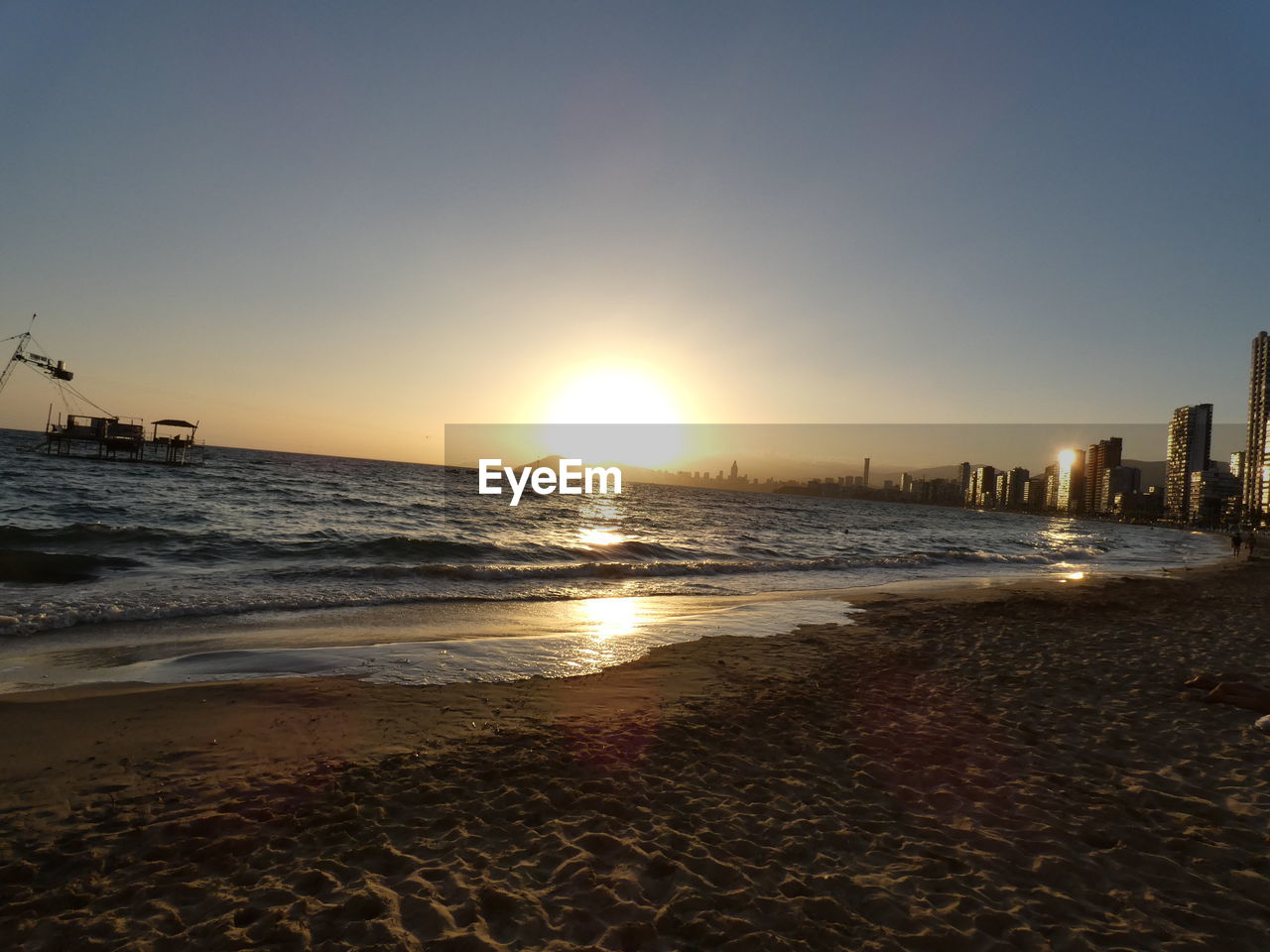 SCENIC VIEW OF BEACH AGAINST SKY AT SUNSET