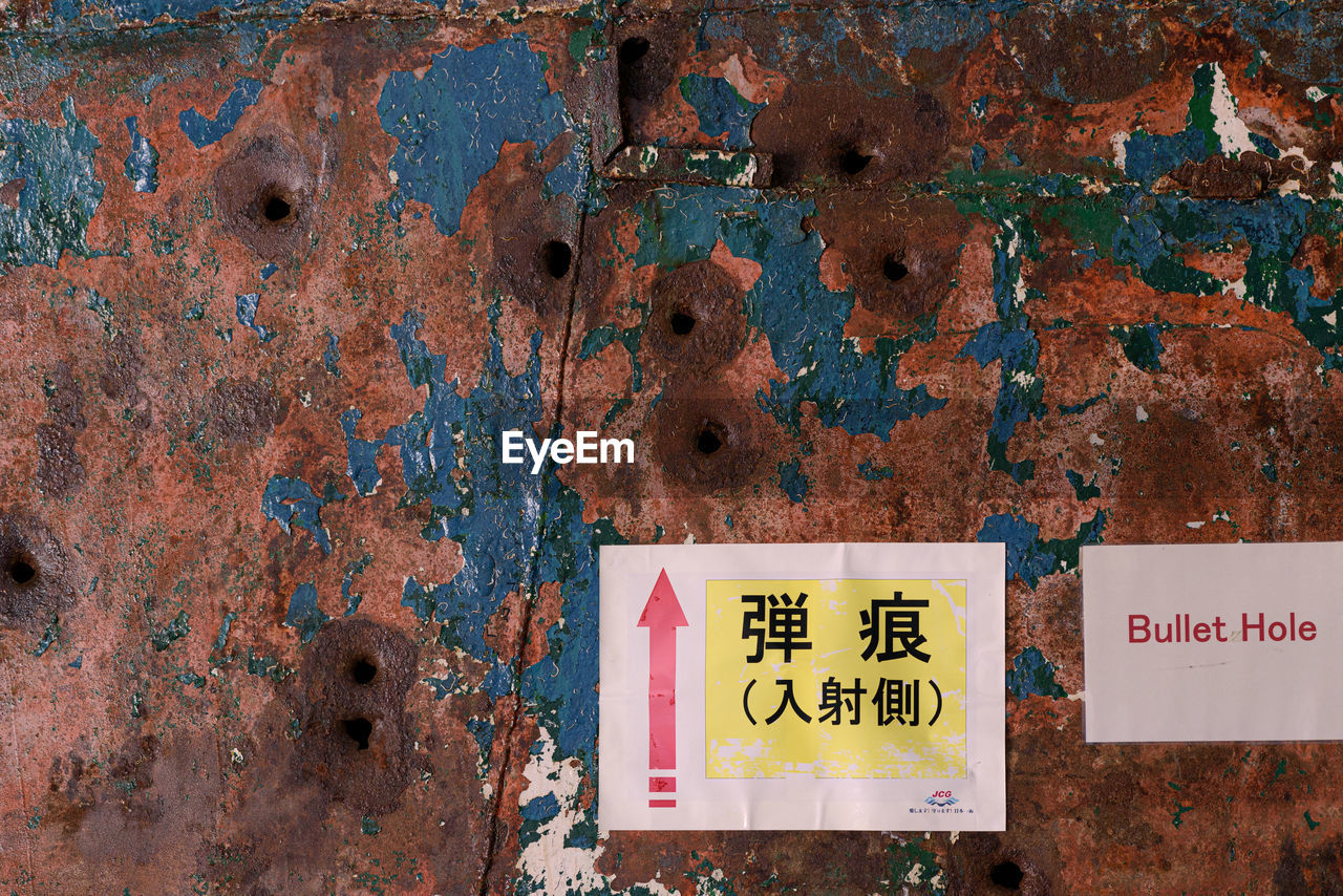 CLOSE-UP OF ABANDONED SIGN ON RUSTY METAL