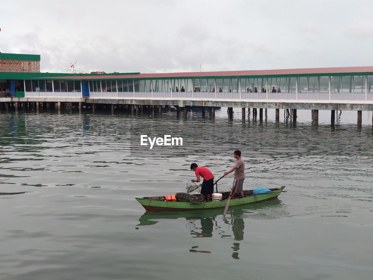 MEN IN BOAT AGAINST SKY