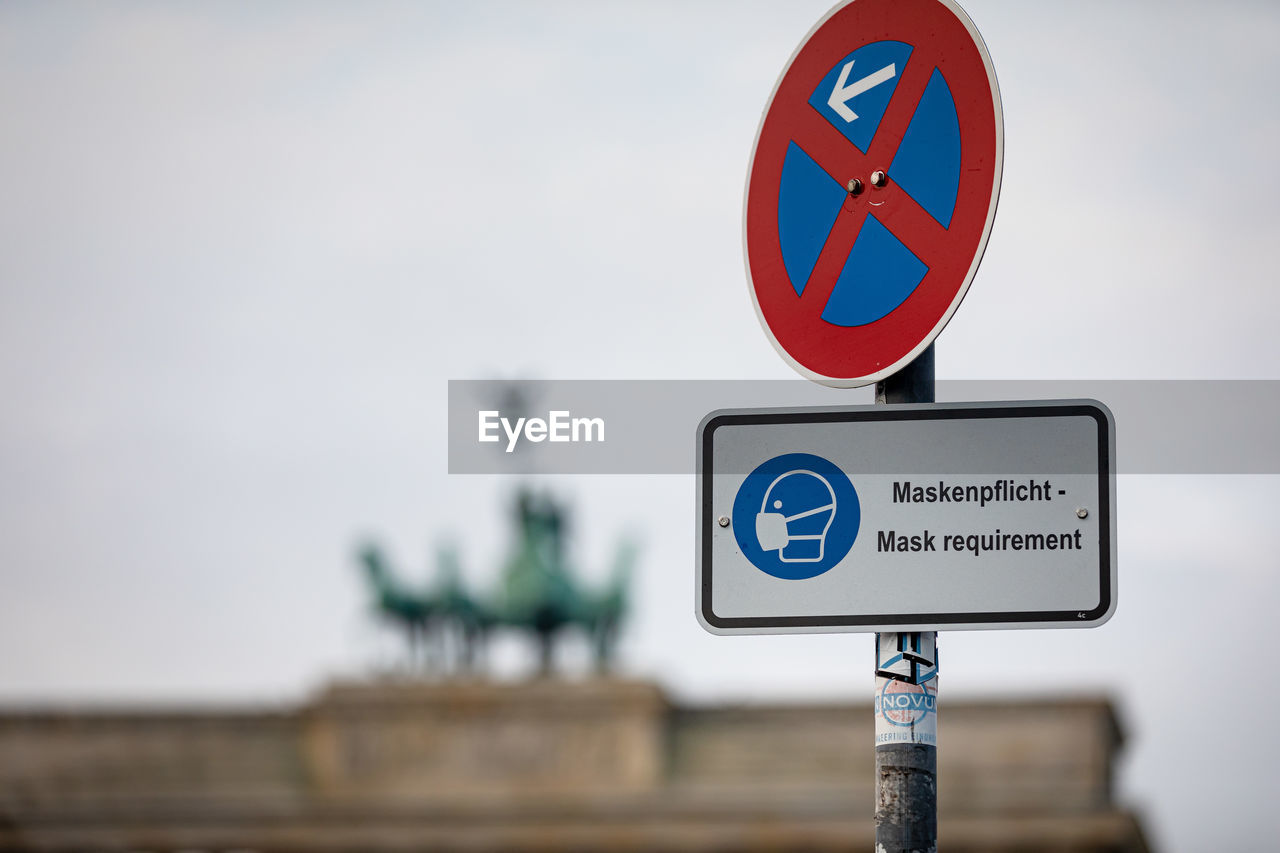 Close-up of information sign against sky