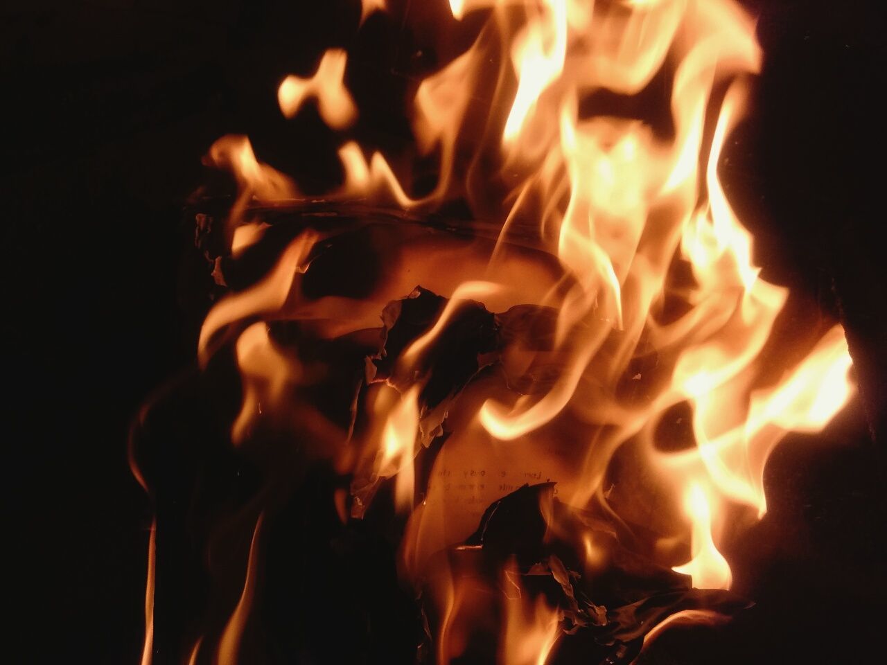 CLOSE-UP OF BONFIRE AGAINST BLACK BACKGROUND AT NIGHT