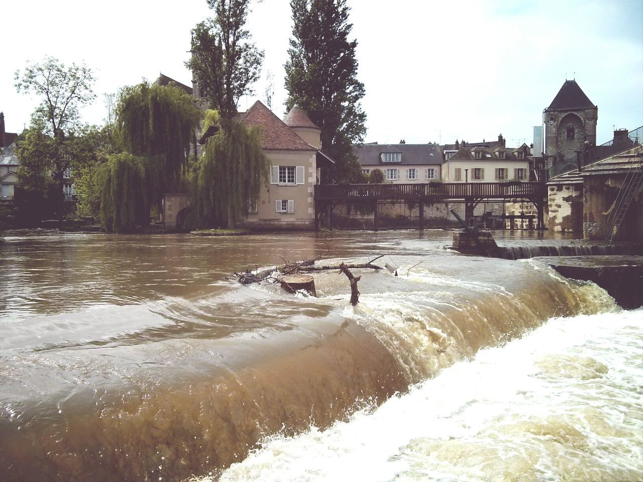 Close-up of flowing river with buildings in background