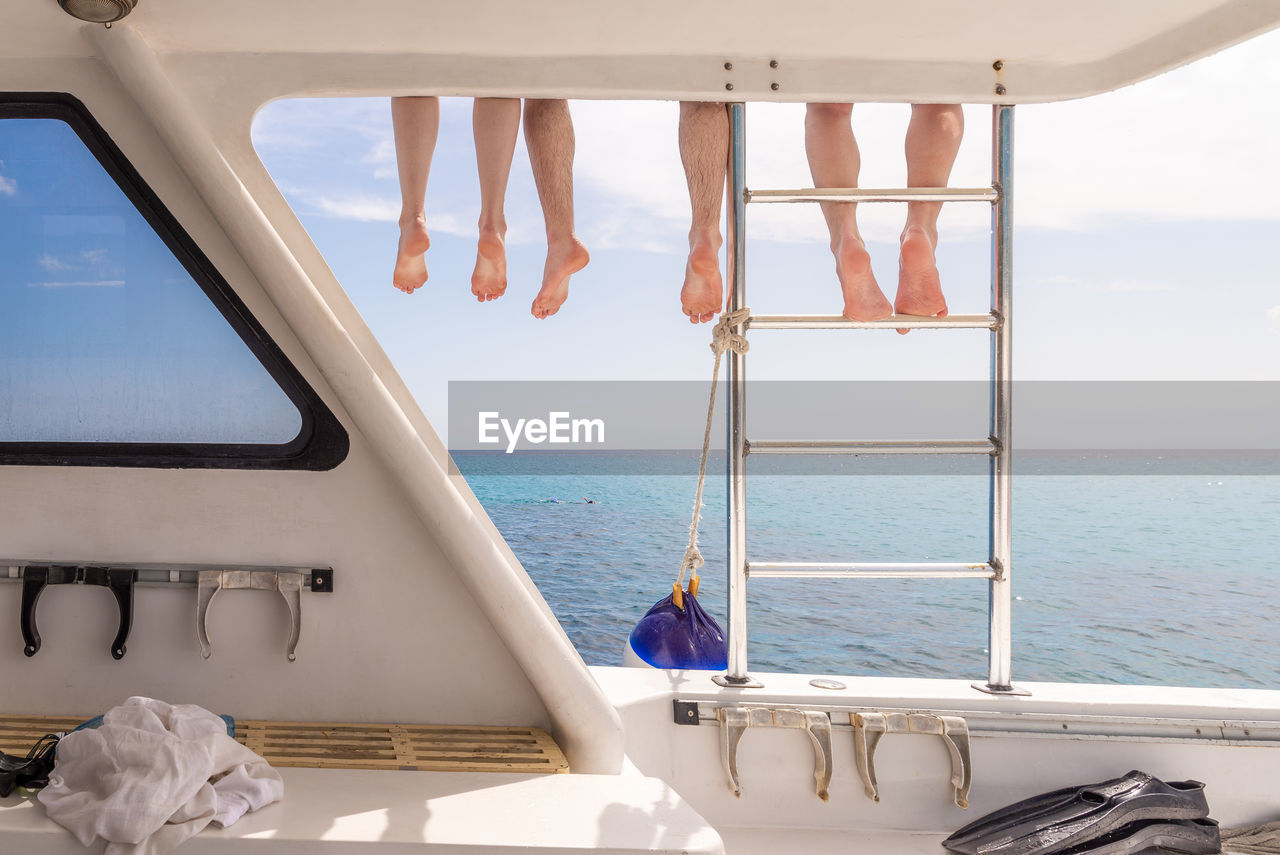 Feet of a group of friends relaxing on the boat deck after snorkeling in the caribbean sea in cuba.