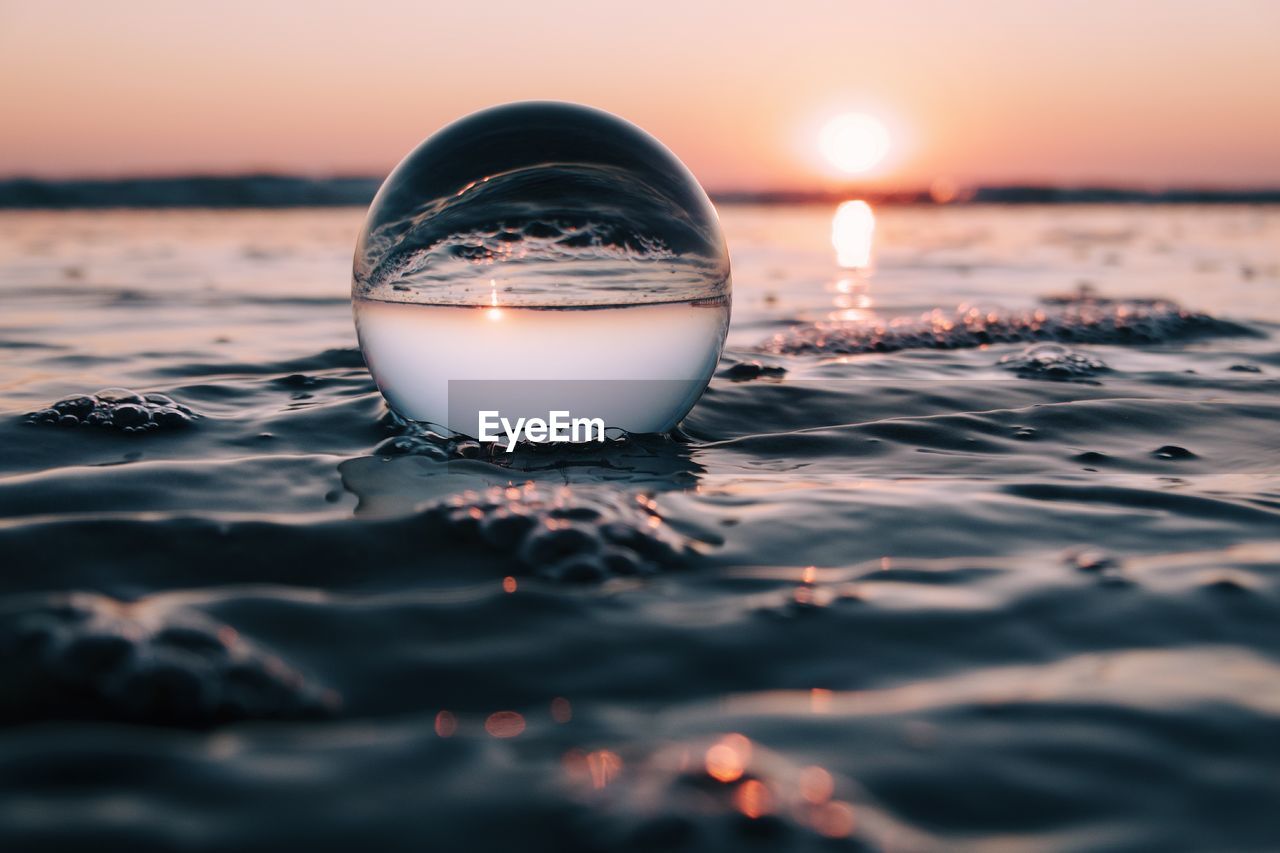 Close-up of crystal ball at sea during dawn