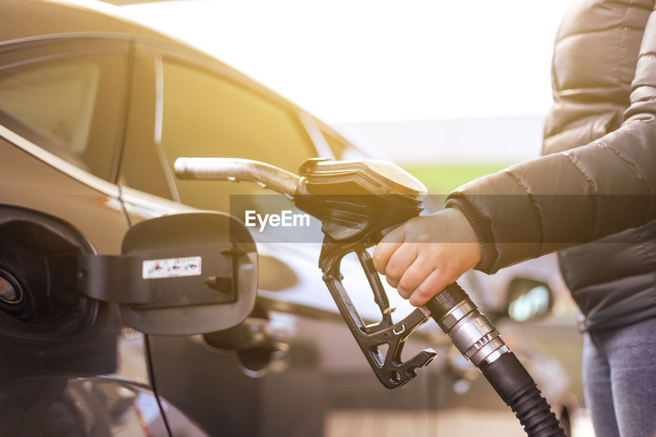 midsection of woman holding steering wheel