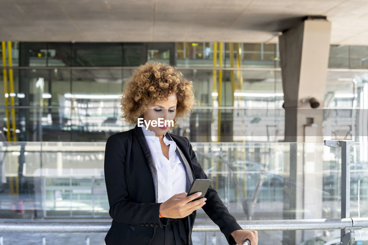 Stewardess in working uniform using her smartphone