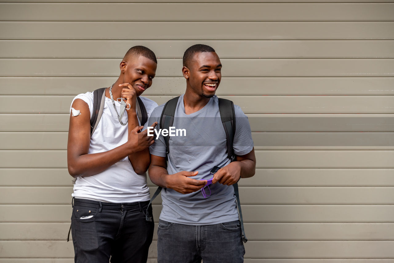 Afro men friends vaccinated showing his arm