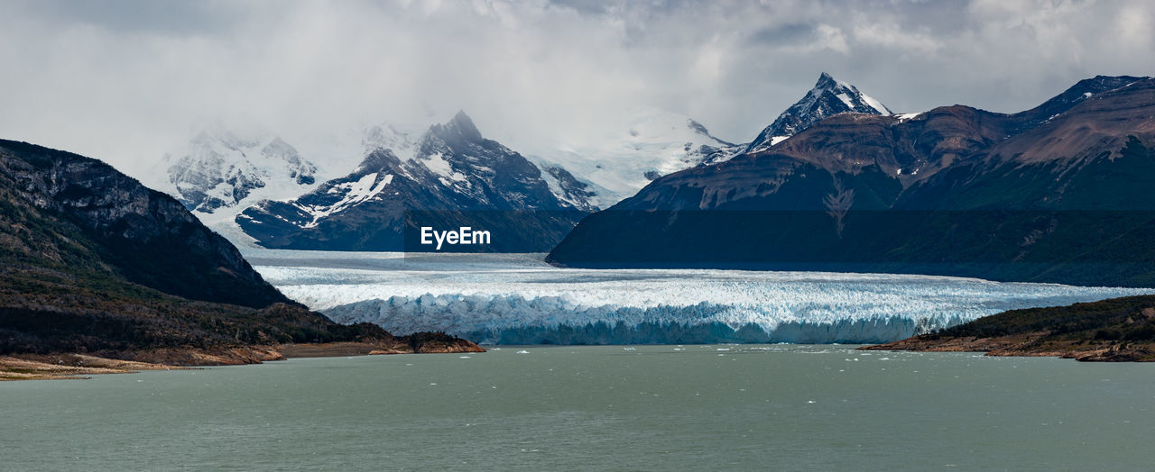 Scenic view of sea and mountains against sky