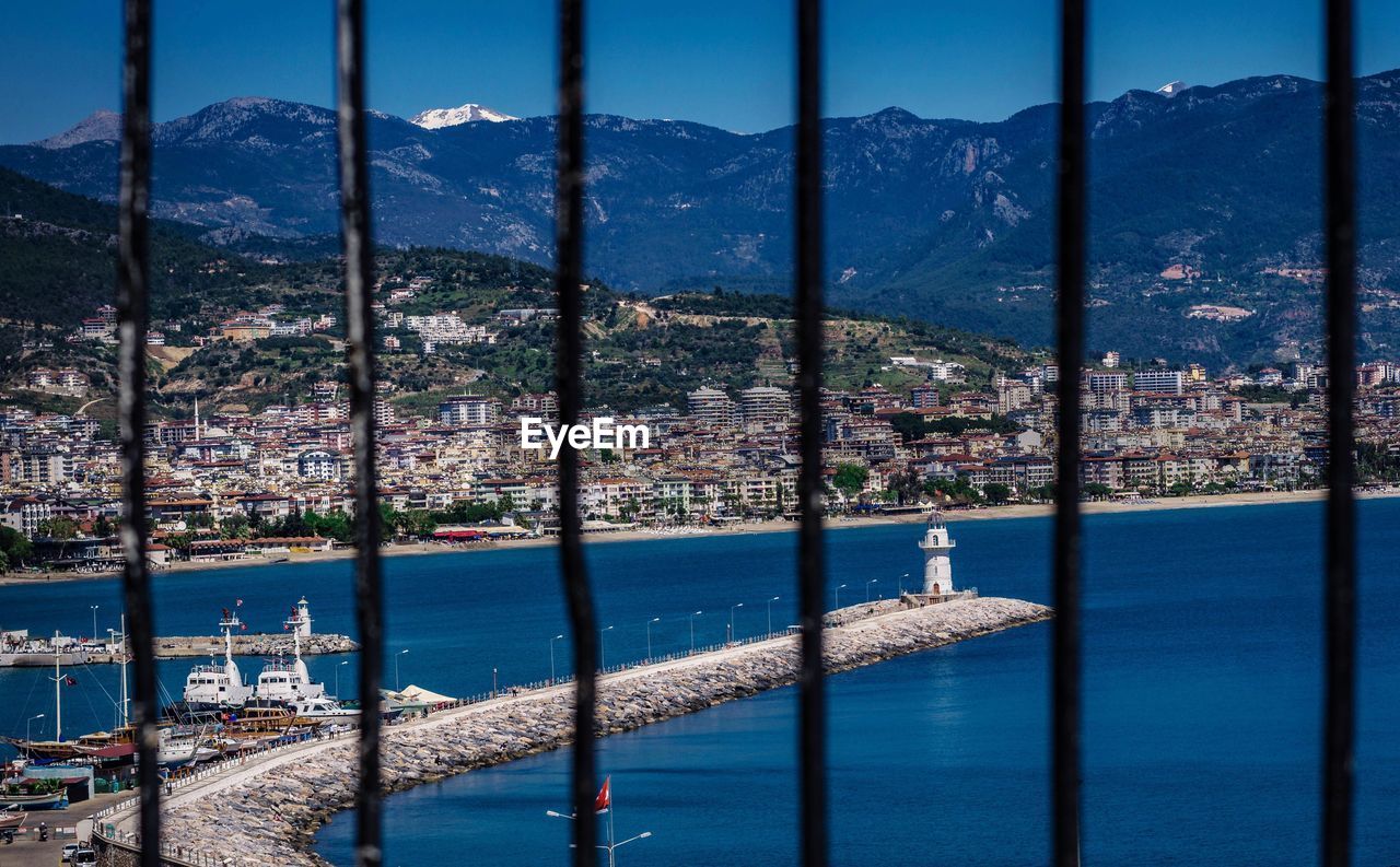 Scenic view of sea and buildings against blue sky