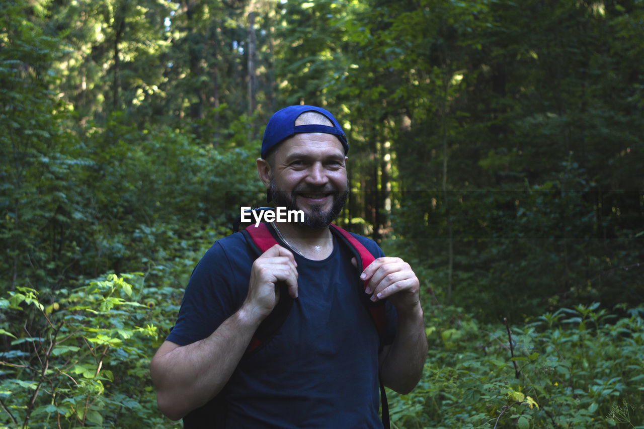 Portrait of smiling man standing in forest