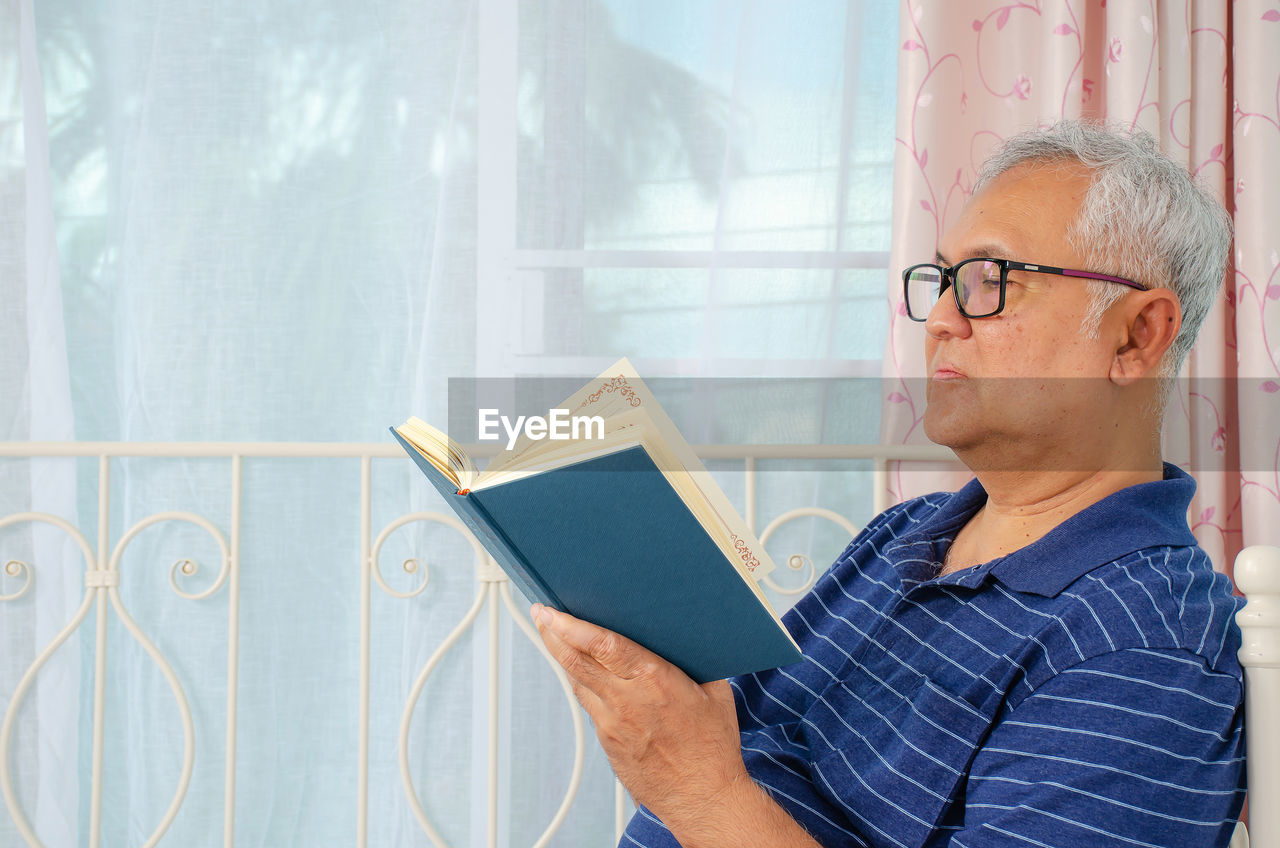 Senior man reading book at home