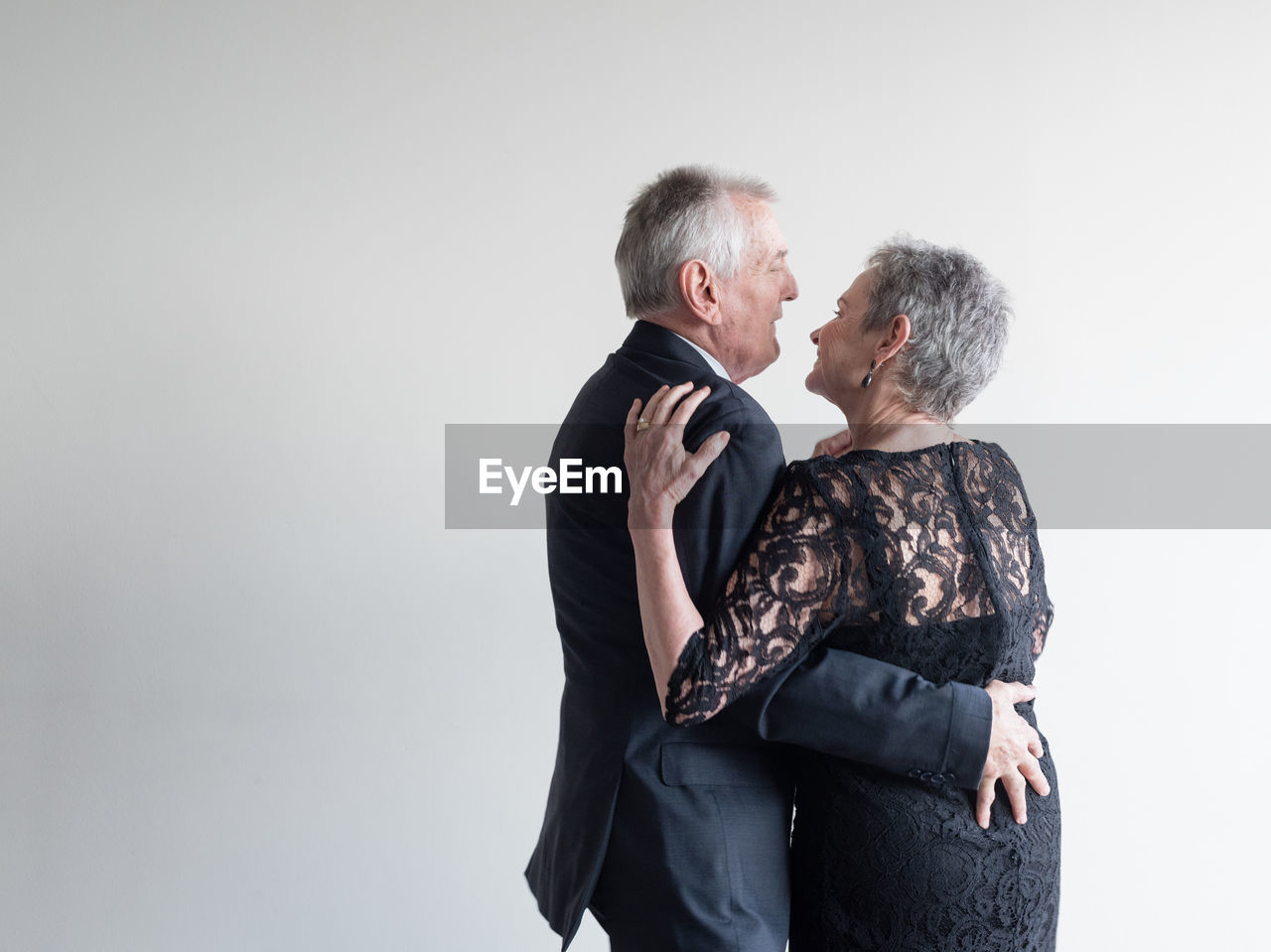 Senior couple dancing against white background