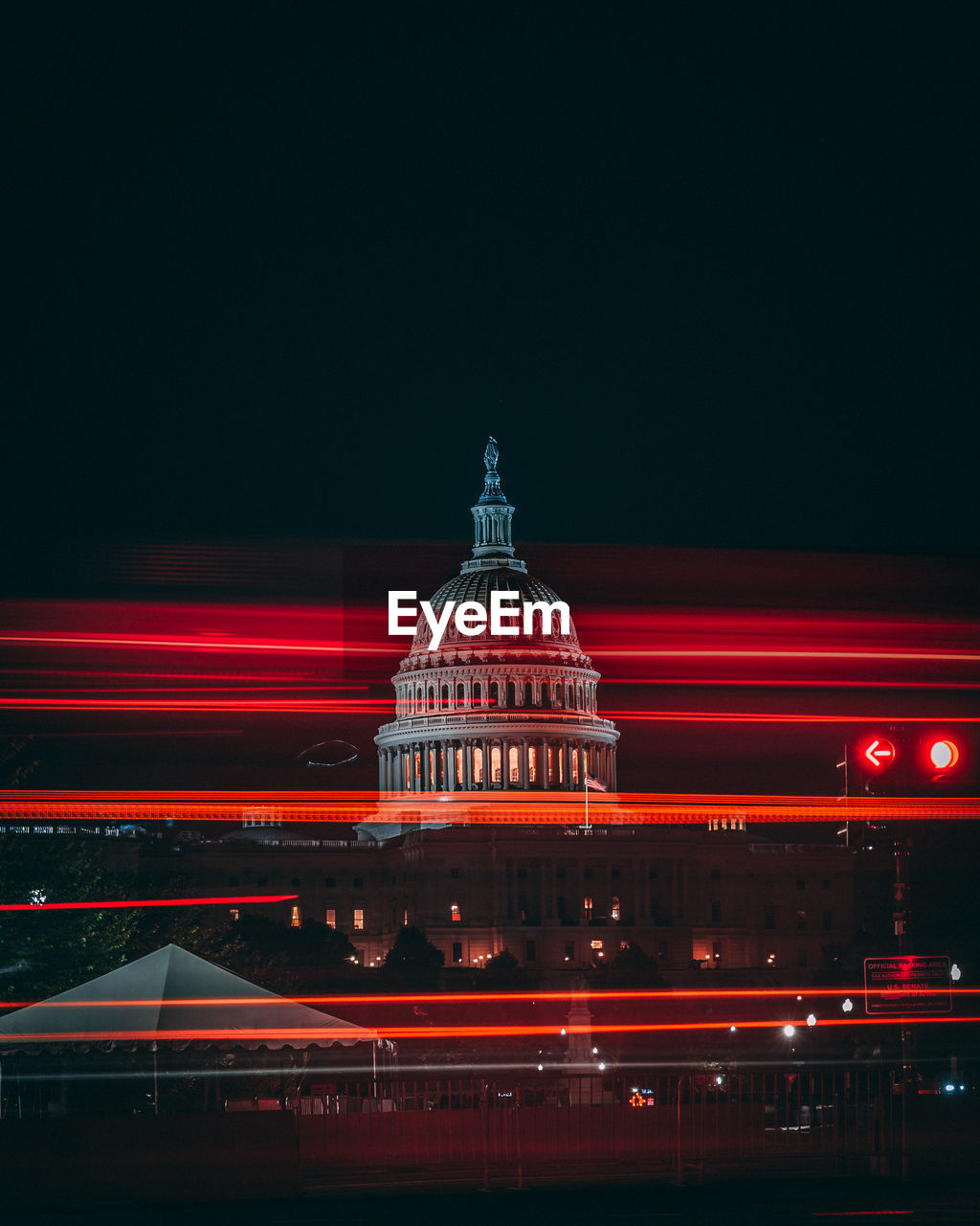 Red light trails against government building at night