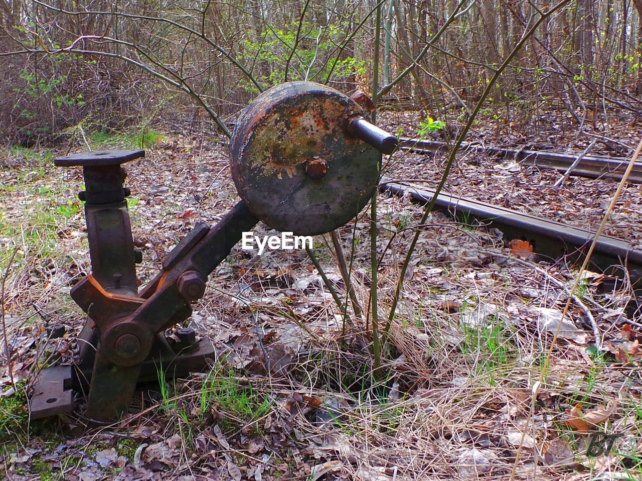Rusty machine by railroad tack in forest