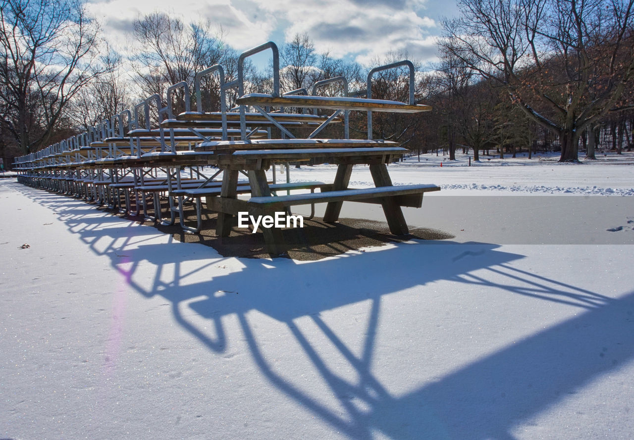 EMPTY PARK BENCH IN SNOW