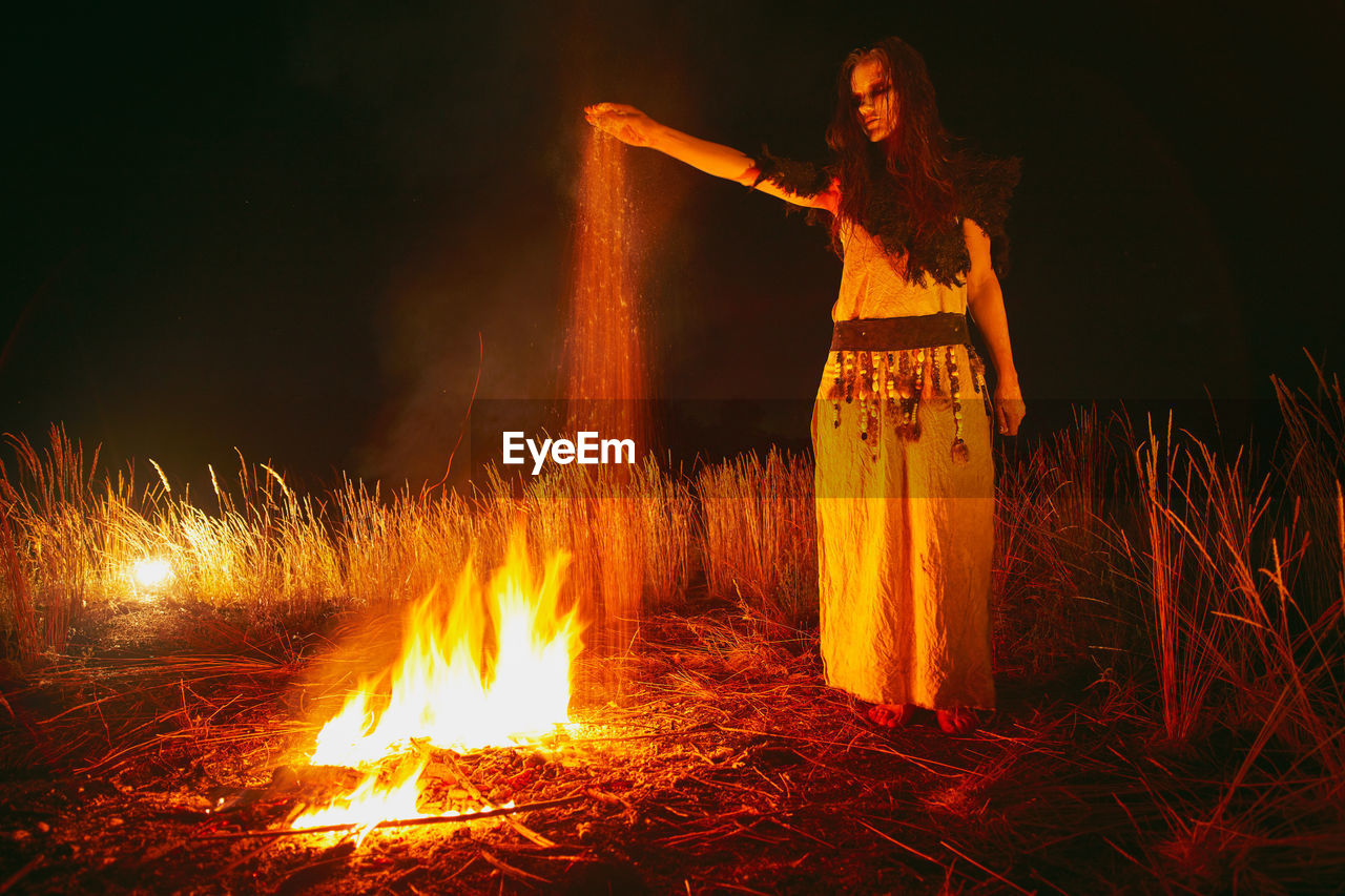 Woman in halloween witch costume throws the ashes of the dead.