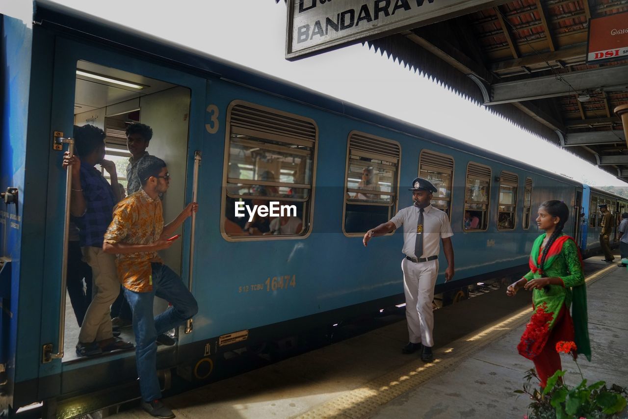 PEOPLE WAITING TRAIN AT RAILROAD STATION