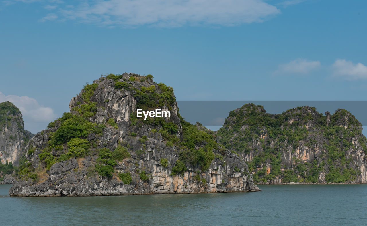 Rock formations by sea against sky