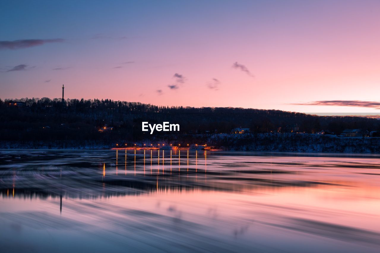 Scenic view of frozen lake against sky at sunset