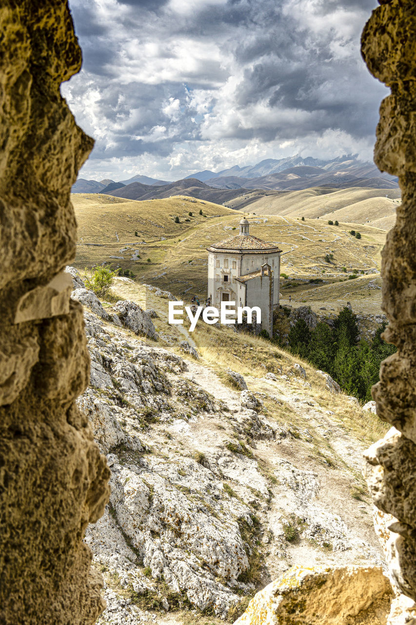 Scenic view of historic building by mountains against sky