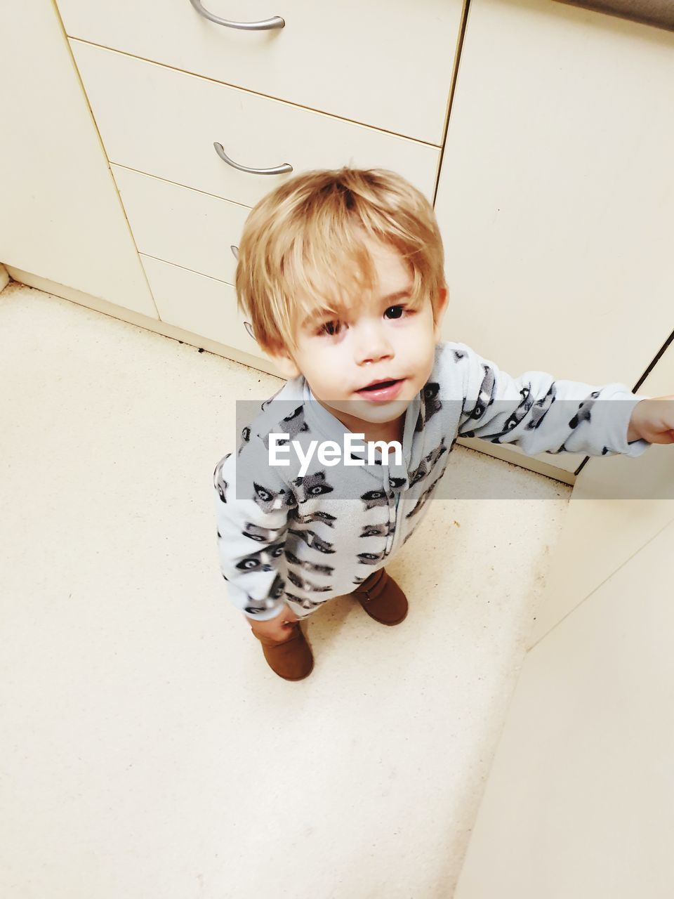 HIGH ANGLE VIEW PORTRAIT OF CUTE BOY STANDING AT HOME