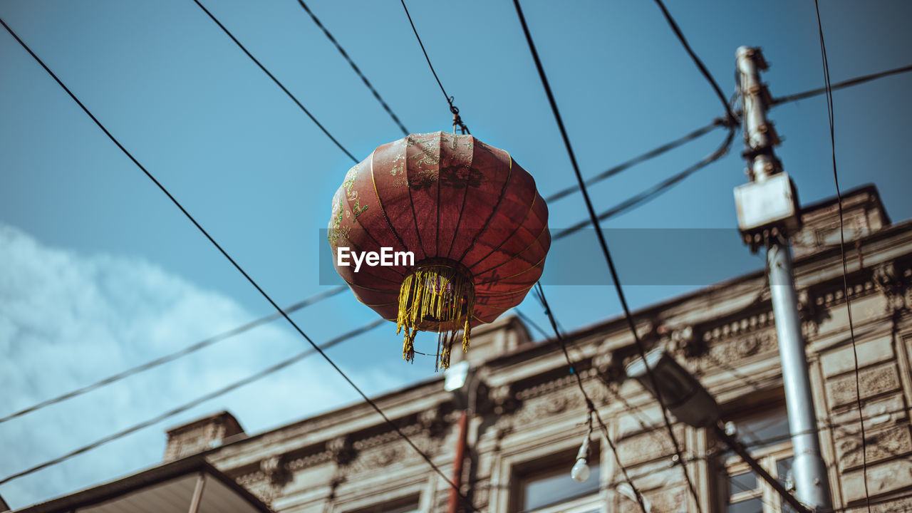 Low angle view of lanterns hanging against sky