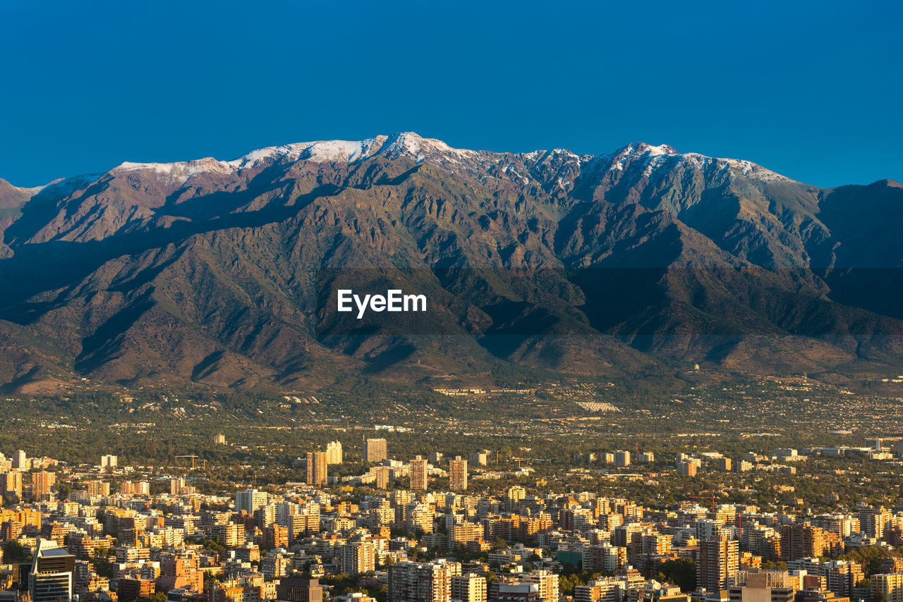 AERIAL VIEW OF CITYSCAPE AGAINST MOUNTAIN