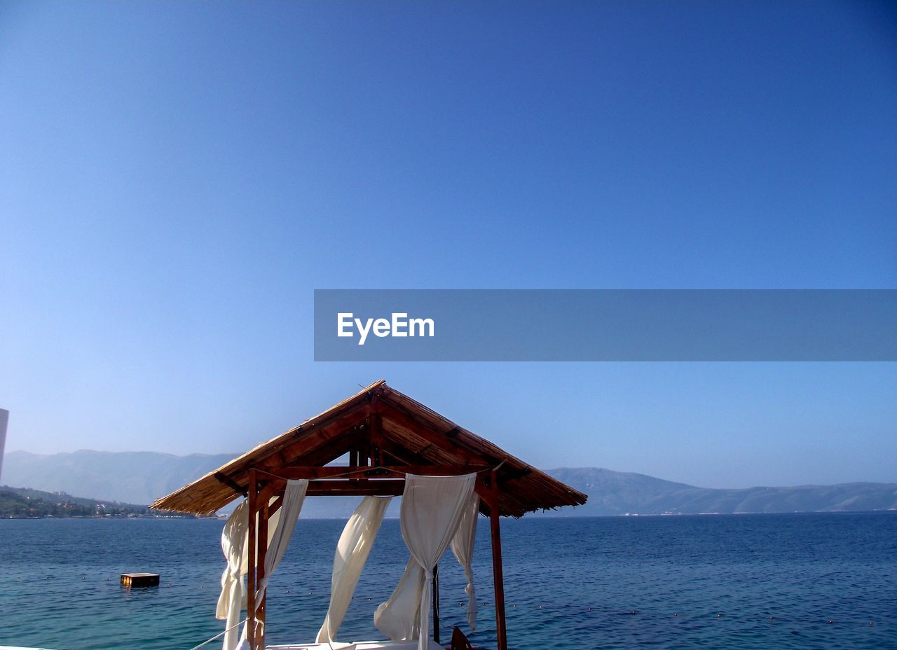 LIFEGUARD HUT ON SEA AGAINST CLEAR SKY