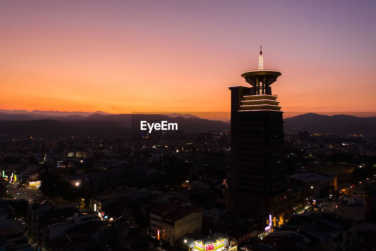 ILLUMINATED BUILDINGS AGAINST SKY AT SUNSET