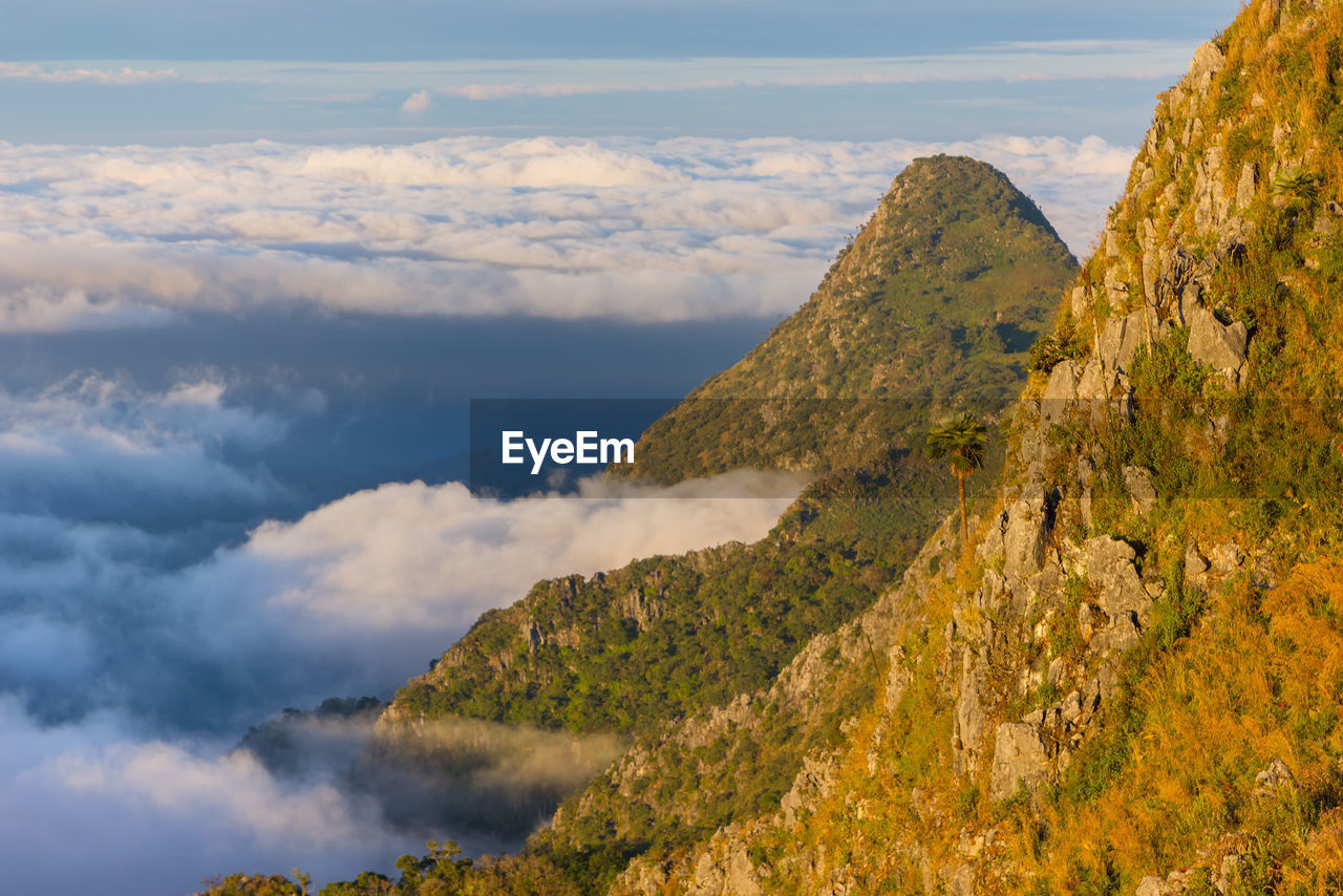 AERIAL VIEW OF MOUNTAIN RANGE AGAINST CLOUDY SKY