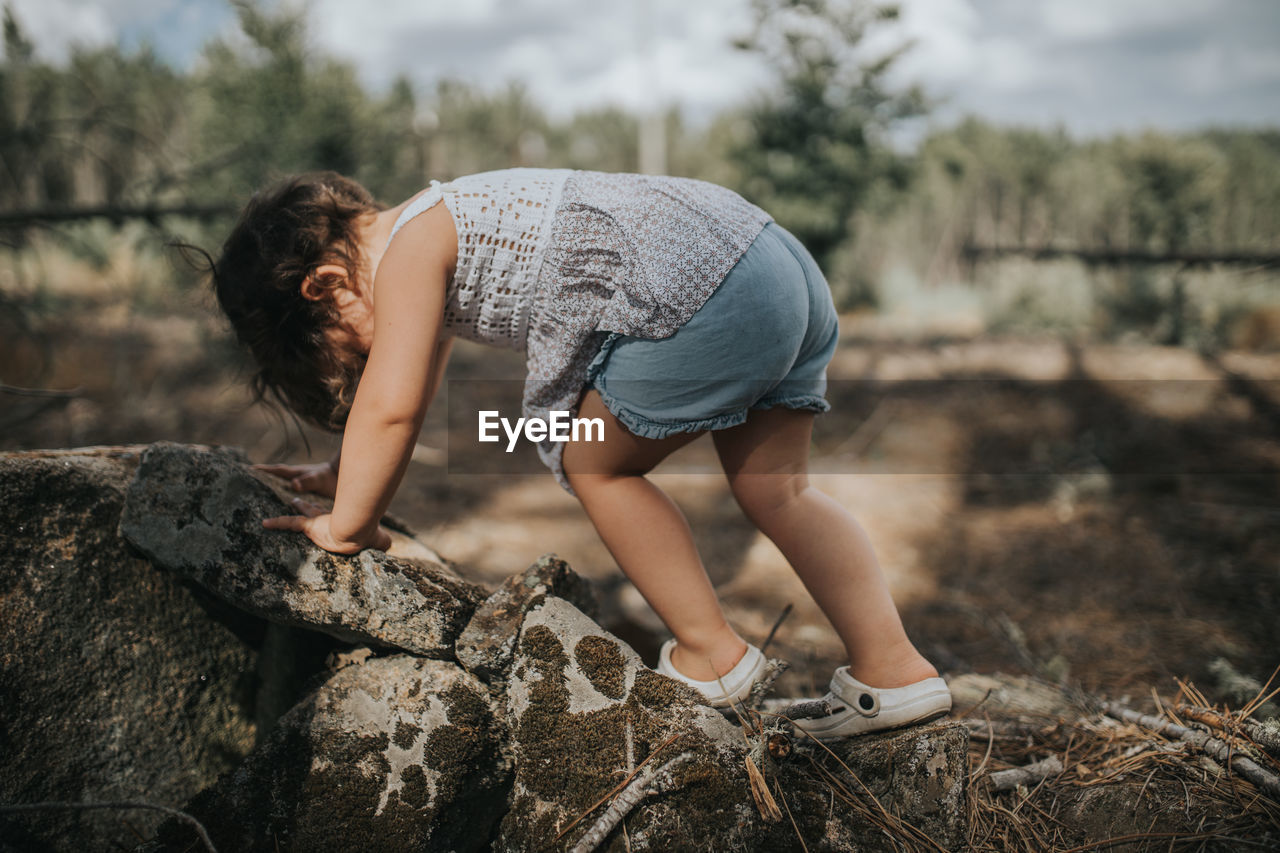 Side view of child on rock