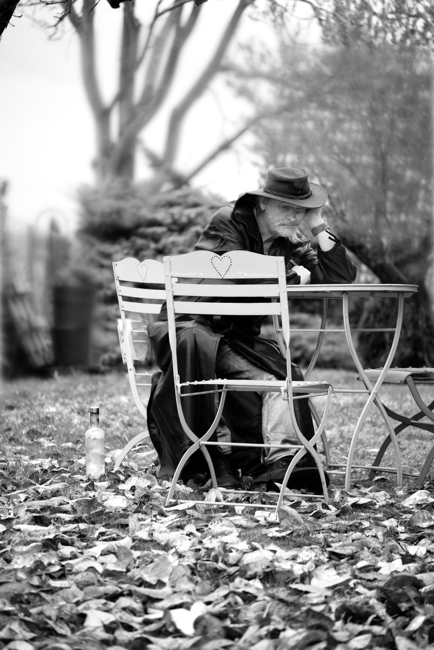 Senior man sitting on chair at yard